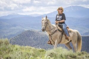 Bar Lazy J Dude Ranch, Parshall CO (2021) Woman riding a horse in a scenic mountain landscape, showcasing outdoor adventure and travel experiences.