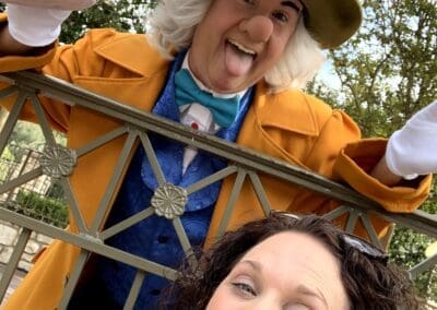 Woman smiling with the Mad Hatter at Disneyland, showcasing joyful interaction in a whimsical setting.