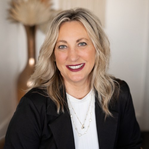 Lora Bohannon, travel advisor at Orange Grove Travel Company, smiling in a black blazer